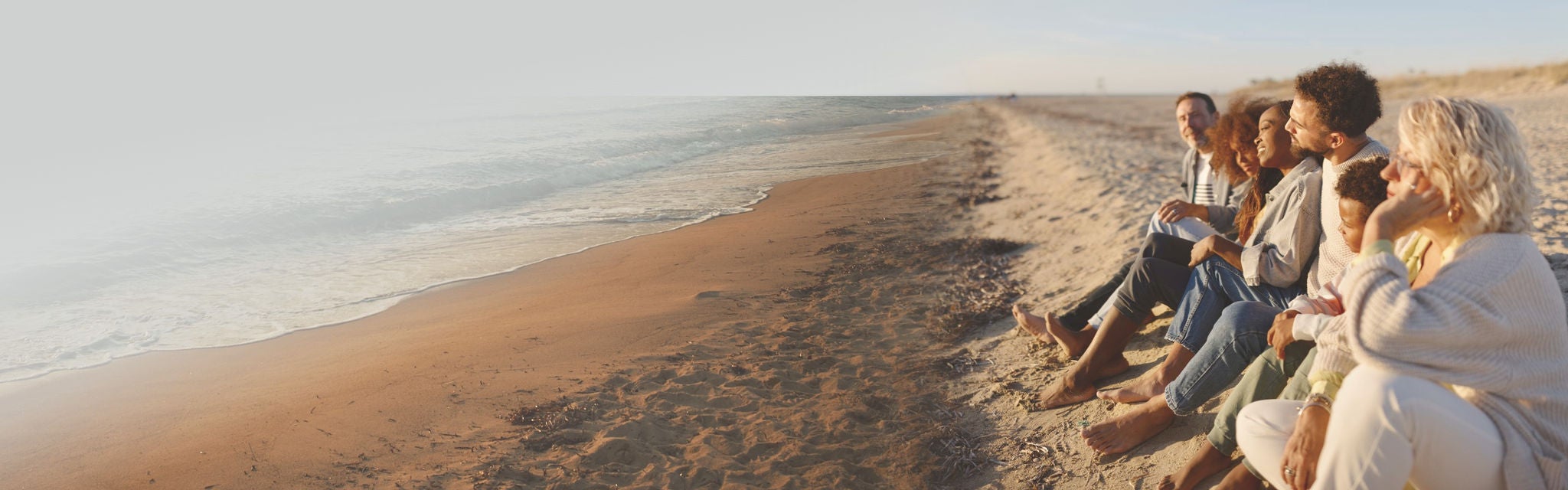 Couple walking on beach while holding hands of each other.